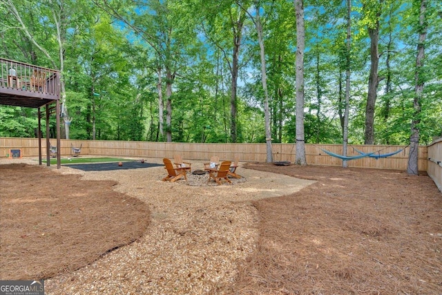 fenced backyard featuring an outdoor fire pit and view of scattered trees