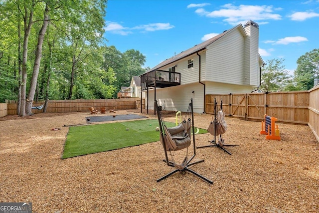 fenced backyard with a patio and a balcony