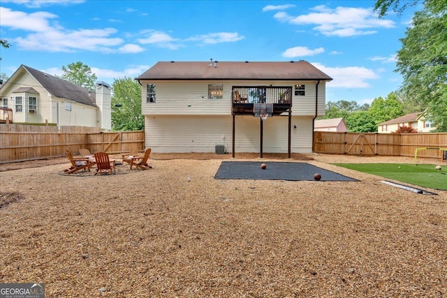 back of house featuring a patio area, a fenced backyard, a fire pit, and a balcony