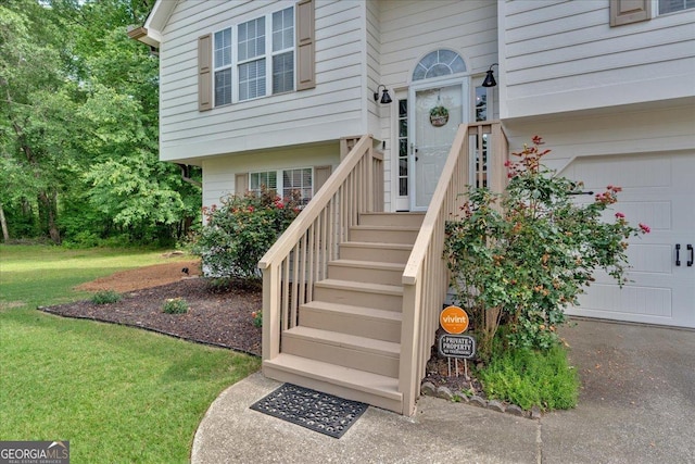 view of exterior entry with a lawn and asphalt driveway