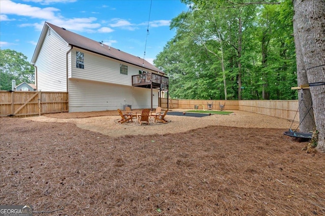 rear view of property featuring a fire pit and a fenced backyard