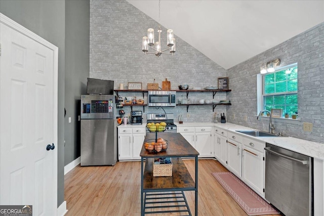 kitchen featuring appliances with stainless steel finishes, a sink, open shelves, a chandelier, and white cabinetry