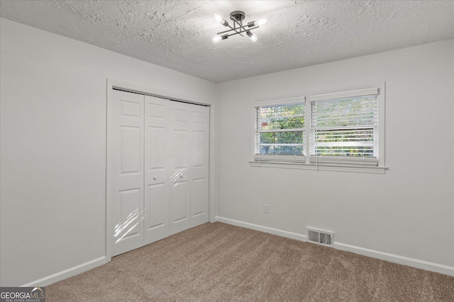 2378 Green Forrest Dr, Decatur, GA 30032 - unfurnished bedroom with carpet flooring, baseboards, a closet, a chandelier, and a textured ceiling