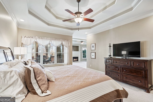 2041 Democracy Dr, Buford, GA 30519 - bedroom featuring ornamental molding, a raised ceiling, light carpet, a warm lit fireplace, and ceiling fan