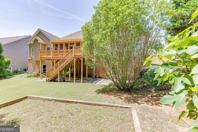 2041 Democracy Dr, Buford, GA 30519 - back of property with a sunroom, stairway, a yard, brick siding, and a wooden deck