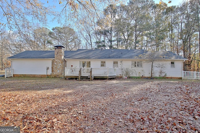 rear view of property with a chimney and a deck