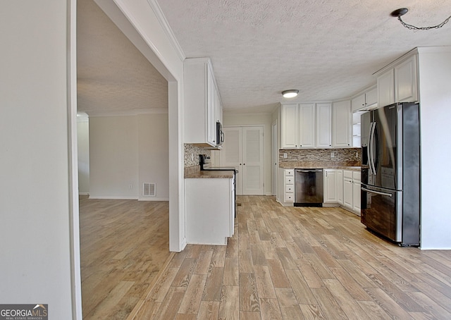 kitchen featuring appliances with stainless steel finishes, light wood finished floors, a textured ceiling, backsplash, and white cabinets