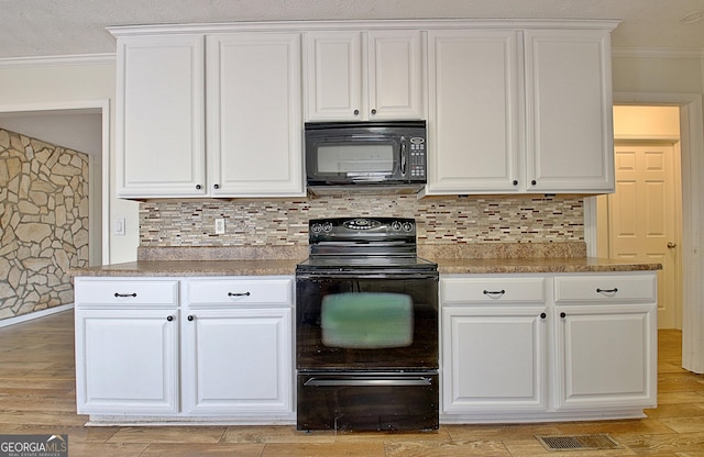 kitchen with black appliances, crown molding, white cabinets, tasteful backsplash, and light wood finished floors