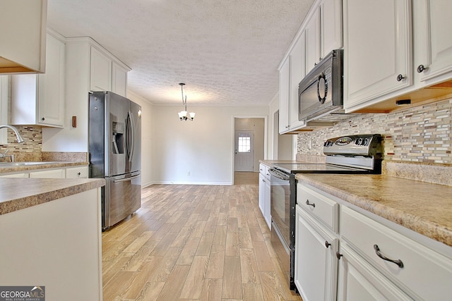 kitchen featuring stainless steel appliances, a sink, white cabinetry, light countertops, and light wood-type flooring