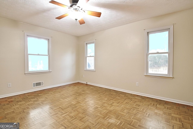 spare room featuring a textured ceiling, ceiling fan, and baseboards