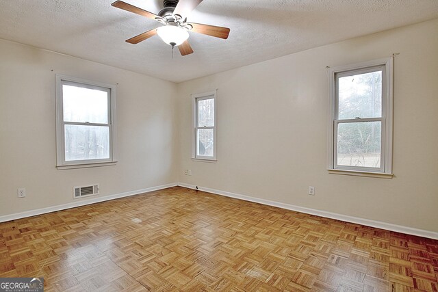 empty room featuring baseboards, a textured ceiling, and ceiling fan