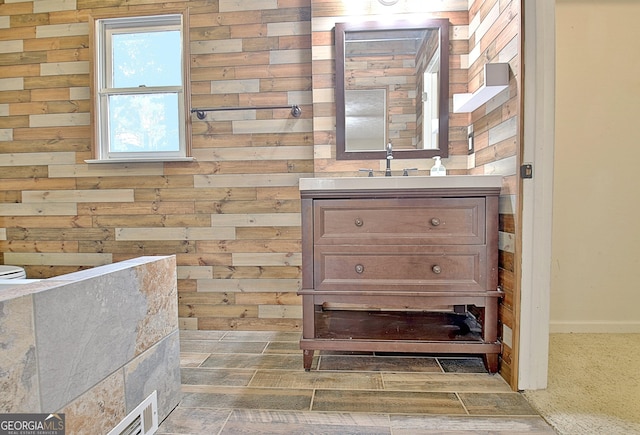 bathroom with vanity, wooden walls, and wood tiled floors