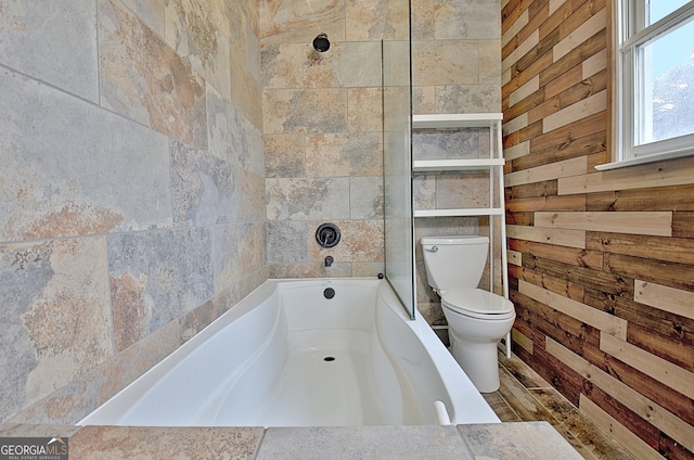 full bath with toilet and wooden walls