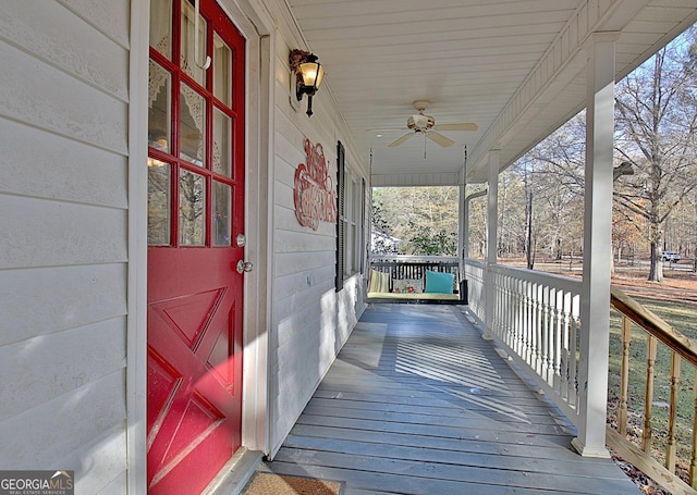 wooden deck with a porch and ceiling fan