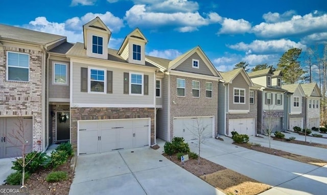 townhome / multi-family property with a garage, driveway, a residential view, and stone siding