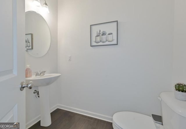 bathroom featuring toilet, wood finished floors, and baseboards