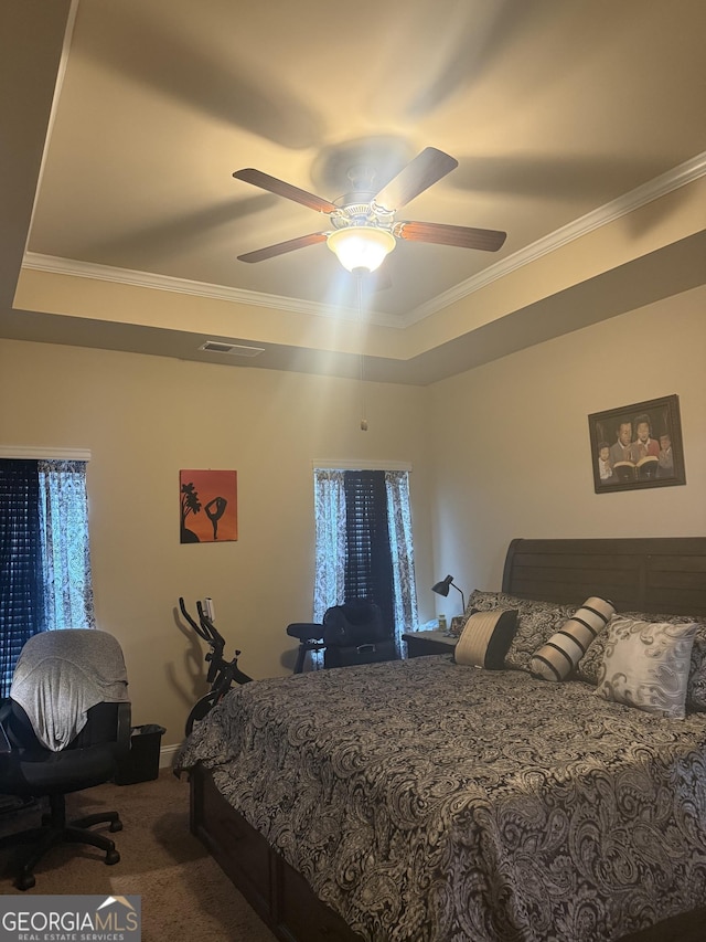 carpeted bedroom with crown molding, a ceiling fan, baseboards, and a tray ceiling