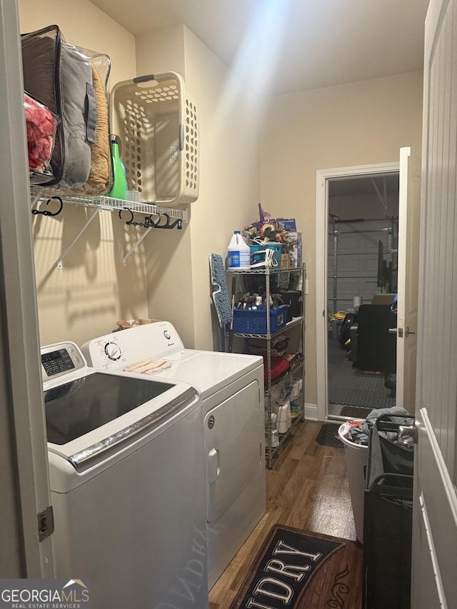 laundry area with washer and dryer and dark wood finished floors