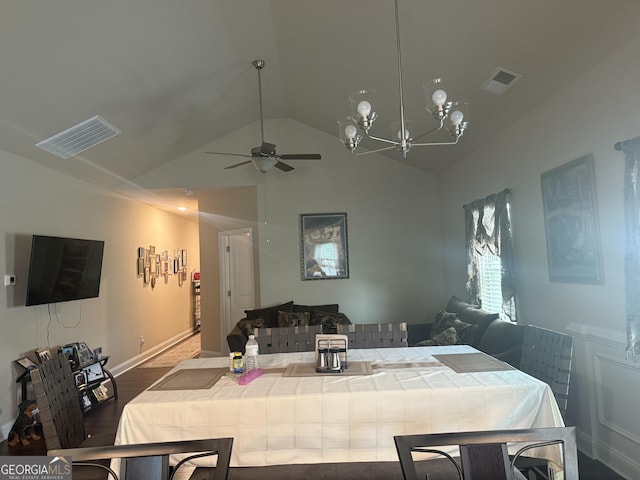 dining area with a chandelier, a ceiling fan, high vaulted ceiling, and dark wood-type flooring