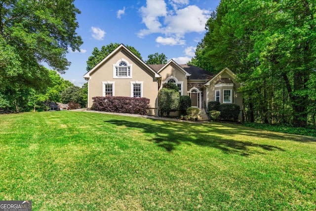 view of front of home featuring a front yard and stucco siding