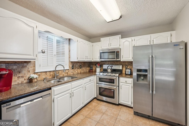 230 Vienna Way, Douglasville, GA 30134 - kitchen featuring appliances with stainless steel finishes, a sink, white cabinetry, a textured ceiling, and tasteful backsplash