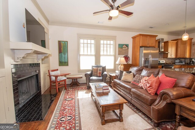 20 Salbide Ave, Newnan, GA 30263 - living area with a ceiling fan, crown molding, a tiled fireplace, and wood finished floors