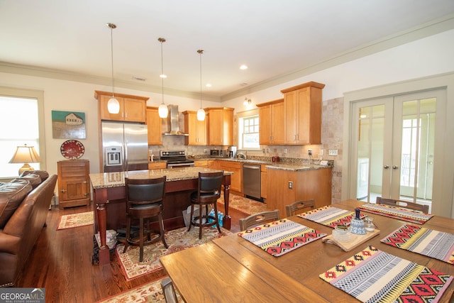 20 Salbide Ave, Newnan, GA 30263 - kitchen with stainless steel appliances, wall chimney exhaust hood, dark wood-style flooring, french doors, and a kitchen breakfast bar