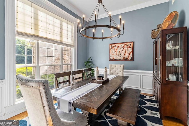 152 Whitaker Way, Hoschton, GA 30548 - dining area with a chandelier, crown molding, a wainscoted wall, a decorative wall, and wood finished floors