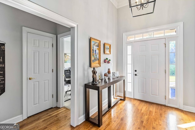 152 Whitaker Way, Hoschton, GA 30548 - foyer entrance featuring light wood-type flooring, baseboards, and a chandelier