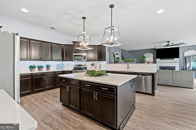9225 Maple Run Trl, Gainesville, GA 30506 - kitchen featuring stainless steel appliances, a ceiling fan, light countertops, hanging light fixtures, and a kitchen island