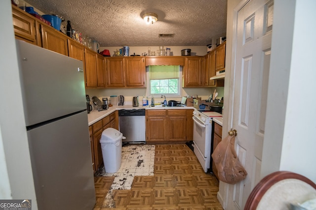 501 Textbook Ct, Lawrenceville, GA 30044 - kitchen featuring appliances with stainless steel finishes, under cabinet range hood, light countertops, brown cabinets, and a textured ceiling