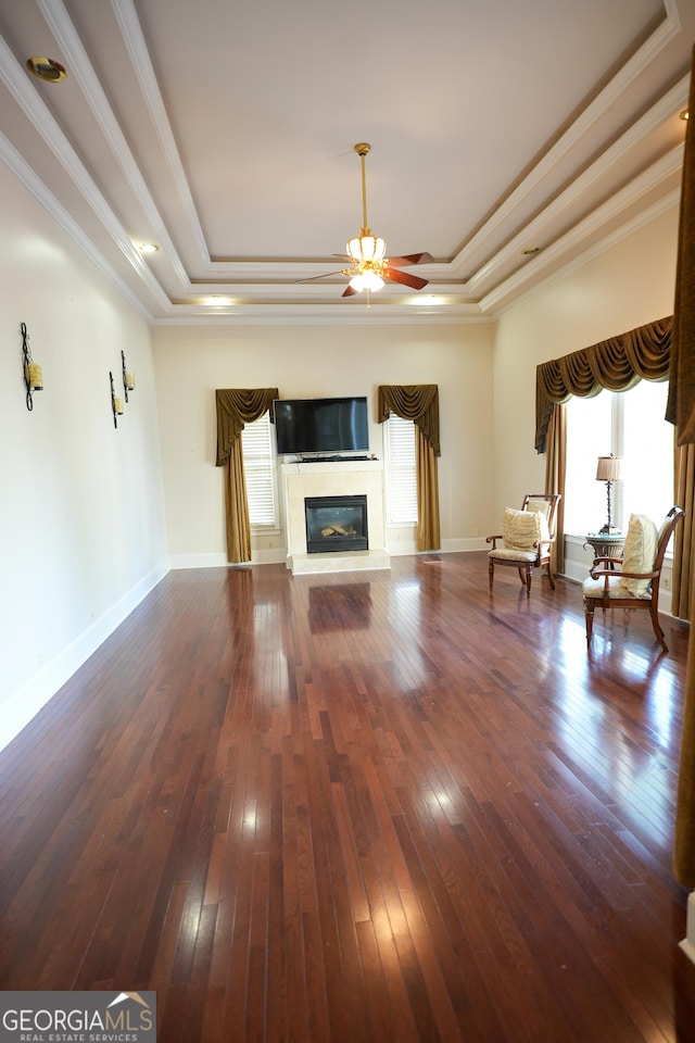 1010 Forest Overlook Dr SW, Atlanta, GA 30331 - unfurnished living room featuring a raised ceiling, ceiling fan, hardwood / wood-style flooring, a glass covered fireplace, and crown molding