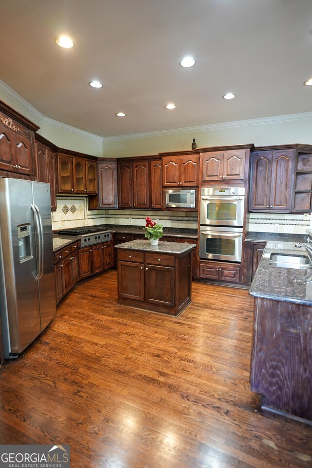 1010 Forest Overlook Dr SW, Atlanta, GA 30331 - kitchen featuring stainless steel appliances, ornamental molding, a sink, dark stone counters, and a kitchen island