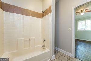 full bathroom featuring tile patterned floors, baseboards, and bathing tub / shower combination