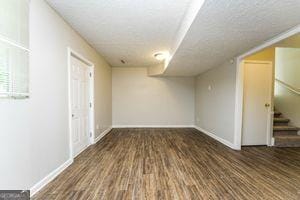 below grade area featuring stairs, wood finished floors, and baseboards