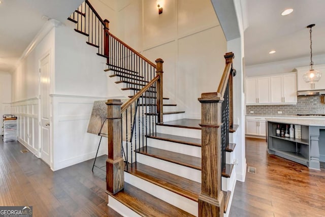 828 Olmsted Ln, Duluth, GA 30097 - staircase with wood finished floors, a decorative wall, crown molding, recessed lighting, and a wainscoted wall