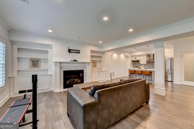 828 Olmsted Ln, Duluth, GA 30097 - living area with a fireplace with flush hearth, light wood-style floors, built in features, crown molding, and baseboards