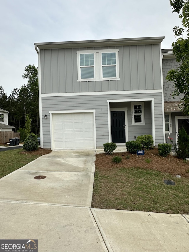 view of front of house with board and batten siding, an attached garage, and driveway