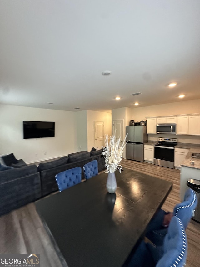 dining room with wood finished floors and recessed lighting