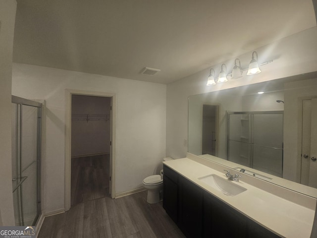 7253 Lacey Dr, Douglasville, GA 30134 - full bathroom with wood finished floors, toilet, a stall shower, vanity, and a spacious closet