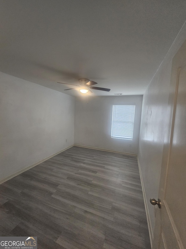 7253 Lacey Dr, Douglasville, GA 30134 - unfurnished room featuring ceiling fan, baseboards, and dark wood-style floors