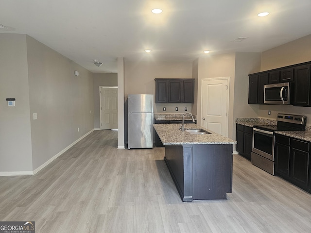 7253 Lacey Dr, Douglasville, GA 30134 - kitchen featuring appliances with stainless steel finishes, a sink, light wood finished floors, light stone countertops, and recessed lighting