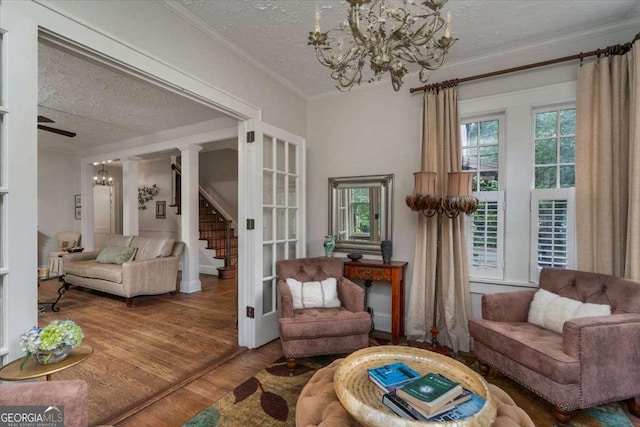 430 Milledge Cir, Athens, GA 30609 - living room featuring a chandelier, a textured ceiling, wood finished floors, ornamental molding, and stairway