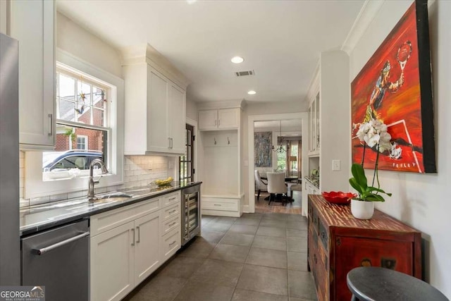 430 Milledge Cir, Athens, GA 30609 - kitchen featuring stainless steel dishwasher, beverage cooler, white cabinets, tasteful backsplash, and a sink