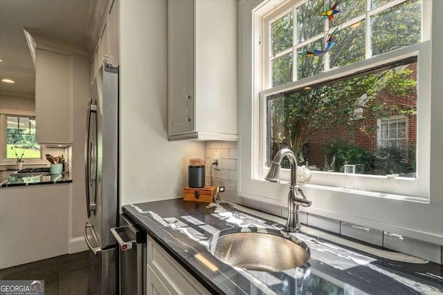 430 Milledge Cir, Athens, GA 30609 - kitchen with dark countertops, freestanding refrigerator, decorative backsplash, a sink, and recessed lighting