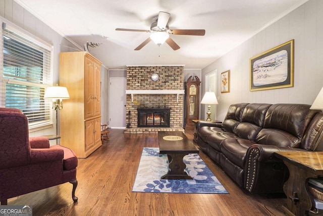 living room featuring ceiling fan, wood finished floors, a fireplace, and crown molding