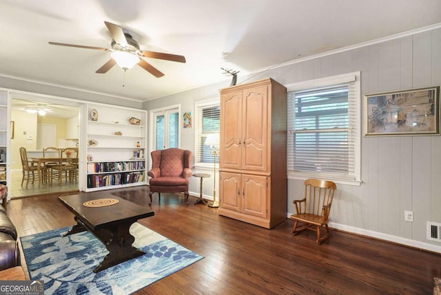 living room featuring a ceiling fan, dark wood-style floors, baseboards, and crown molding