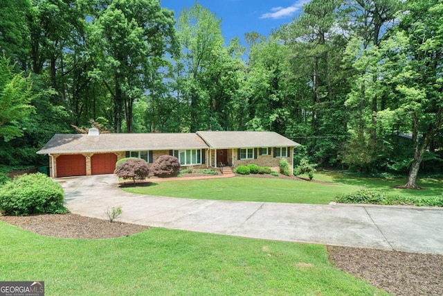single story home with a garage, concrete driveway, a front yard, and a chimney