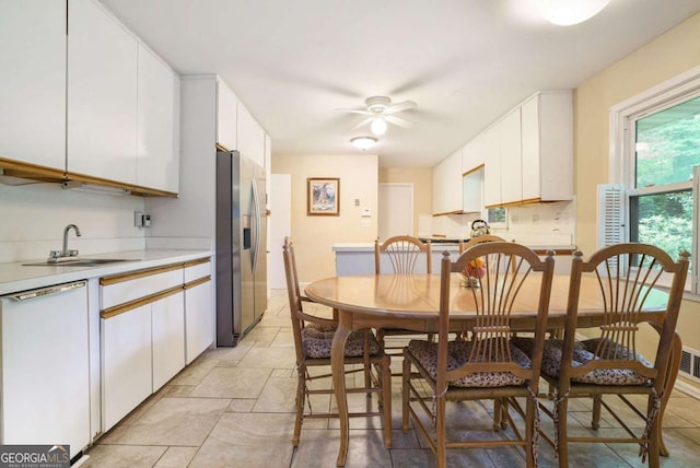 dining area with ceiling fan and light stone finish flooring