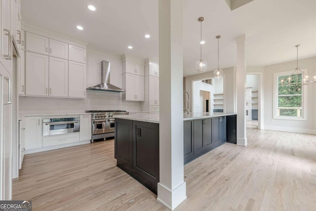 2555 Chattahoochee Ln, Cumming, GA 30041 - kitchen featuring wall chimney range hood, double oven range, light wood-style flooring, recessed lighting, and hanging light fixtures